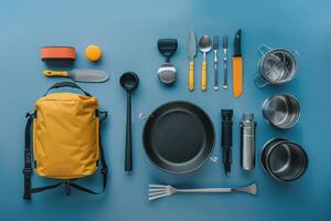 Brightly colored camping gear arranged neatly on a blue surface, showcasing tools for cooking and outdoor adventures photo