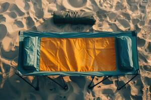 A serene campsite setting with a folded camping cot, beckoning adventures under the golden sun on a sandy beach photo