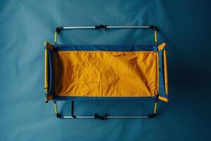 Comfortable outdoor camping cot set up on a blue backdrop, ready for use during a relaxing evening under the stars photo