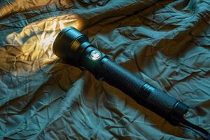 A powerful flashlight beams light across a textured fabric backdrop in a dimly lit room during nighttime exploration photo