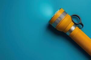 A bright yellow flashlight resting on a vibrant blue surface, illuminating the area with a warm glow, inviting exploration and adventure at any time of day photo