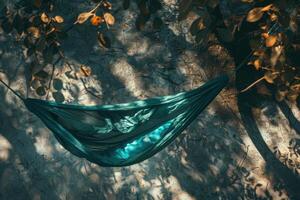 A tranquil hammock sways in the dappled sunlight beneath leafy branches on a serene afternoon photo