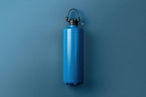 A vibrant blue gas cylinder against a serene blue backdrop, showcasing industrial elegance and design simplicity photo