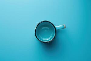 A simple turquoise cup rests on a vibrant blue surface, inviting warmth and comfort in a cozy setting photo