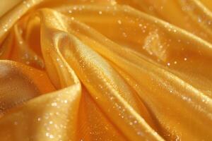 Soft golden fabric with sparkles draped elegantly on a surface photo