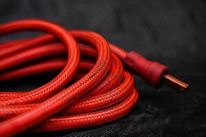 Close-up of a twisted red electrical extension cord on a dark background photo
