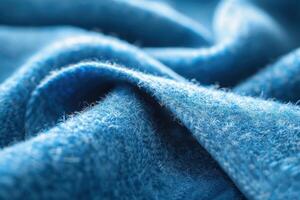 Close-up view of textured blue fabric showcasing fine fibers and intricate weave patterns in soft lighting photo