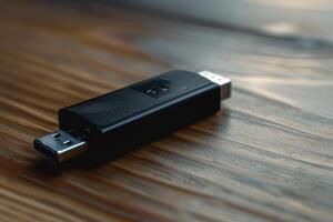 A black USB drive resting on a wooden table in soft natural light photo
