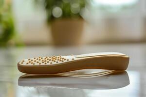Comfortable foot insole with textured surface placed on a table near a window with houseplants in natural light photo