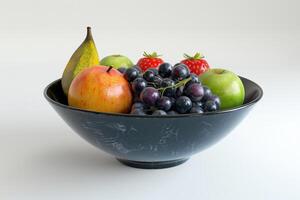 Fruit bowl with apples, grapes, strawberries, and a pear on a neutral background photo