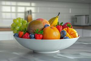 Fresh fruit bowl with strawberries, bananas, and grapes on a kitchen counter photo