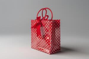 A red polka dot gift bag with a bow displayed on a neutral background photo