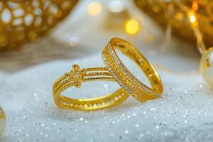 Elegant gold and diamond rings resting on glittering snow with warm background lights photo