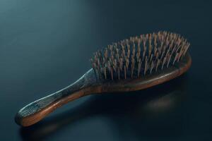 A wooden hairbrush with fine bristles resting on a smooth surface in natural light photo