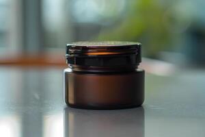 Dark glass jar on a reflective surface with blurred background in a well-lit environment photo