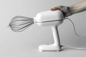 Handheld mixer in use with a white finish against a plain background photo