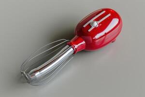 Red handheld electric mixer with a stainless steel whisk attachment on a gray countertop in a modern kitchen photo