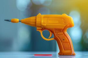 A bright orange plastic toy gun designed for kids, resting on a table with a red cap nearby during daylight photo