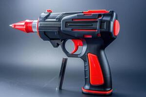 A toy water blaster with a red and black design displayed against a dark background photo