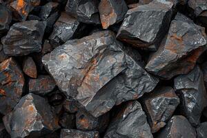 Close-up of dark volcanic rocks with orange textures on their surface, showcasing natural geology in a rugged landscape photo