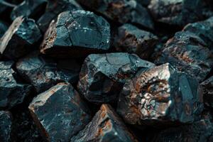 Close-up view of shiny black coal pieces stacked in a pile during daylight photo