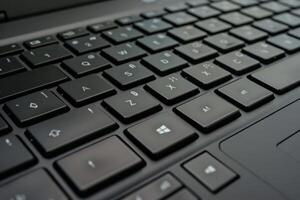 Close-up of a laptop keyboard focusing on black keys and details showing technology in use photo