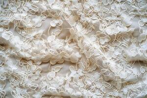 Delicate ivory lace fabric featuring floral embroidery on a textured background photo