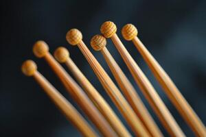 Close-up of wooden knitting needles arranged in a line against a dark background photo