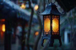Lantern hanging in a serene garden at dusk with warm light illuminating the surroundings photo