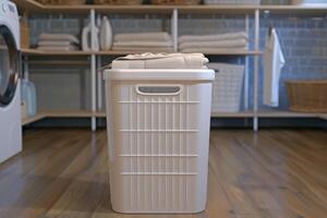 Neatly stacked towels atop a laundry basket in a bright laundry room with wooden floors and organized shelving photo