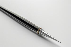 Close-up of a sleek silver and black pen resting on a white surface photo