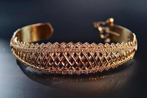 Elegant gold cuff bracelet with intricate diamond patterns displayed against a dark background photo