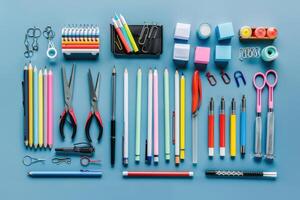 A variety of colorful stationery items neatly arranged on a blue background for creative projects photo