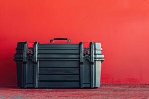 Black storage box on a red wall in a workshop setting photo