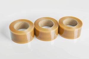 Three rolls of clear packing tape arranged neatly on a white background photo