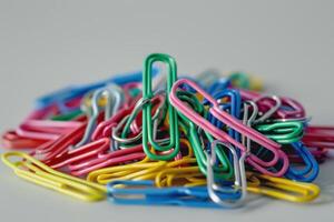 A colorful collection of paper clips scattered on a light surface photo