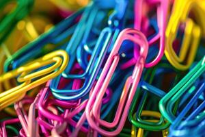Colorful assortment of paperclips arranged randomly on a surface photo