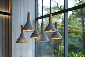 Elegant modern pendant lights hanging in a cozy interior space surrounded by large windows with greenery outside photo