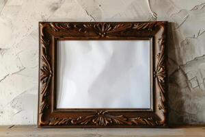 Ornate wooden picture frame resting against a textured wall with blank center, ideal for displaying art or memories photo