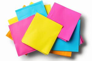 Colorful stack of paper sheets in vibrant shades of blue, yellow, pink, and orange set against a white background photo