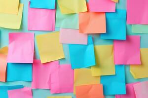 Colorful sticky notes arranged randomly on a light blue background, showcasing vibrant hues of pink, yellow, and green photo