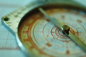Close-up of a vintage compass on a map, showcasing intricate details and markings during daylight photo