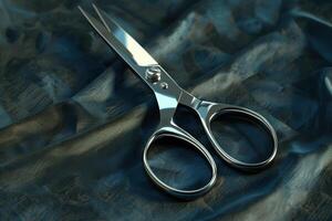 Shiny stainless steel scissors resting on a textured dark fabric surface in soft lighting photo