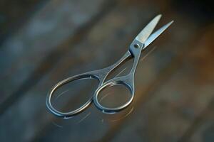 Close-up of metallic scissors resting on a reflective surface in a well-lit room during the day photo