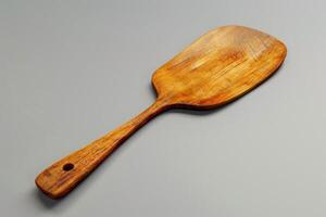 Wooden spatula resting on a grey surface in a well-lit kitchen setting photo