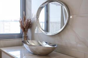 Modern bathroom sink and round mirror with natural decor in a bright space photo