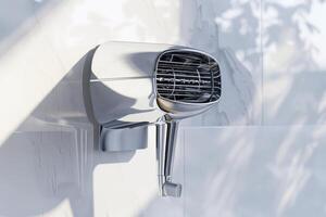 Modern hand dryer mounted on a restroom wall, featuring a sleek design and efficient airflow photo