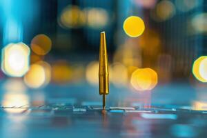 A golden pen stands upright on a blurred keyboard with city lights in the background during twilight photo