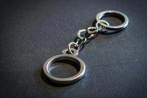 A simple metal keychain with a circular loop on a dark surface showcasing its sleek design and functionality photo