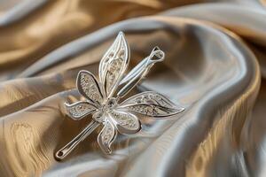 A delicate silver butterfly hairpin rests on soft golden fabric photo